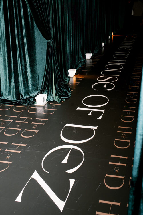 Custom black event carpet with bold white lettering for a luxury celebration by DELSIE, event planners Miami Florida.
