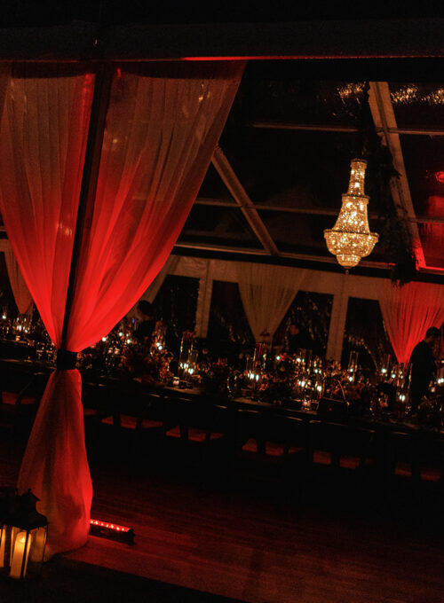 Romantic tented wedding reception with dramatic lighting, designed by DELSIE, luxury event planners in Miami, Florida.