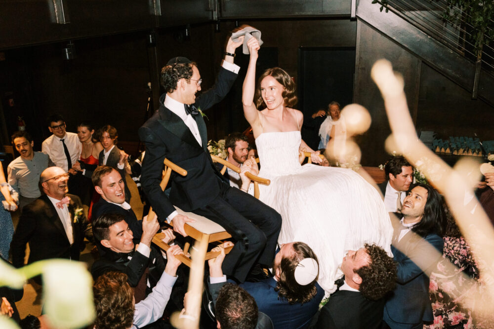 Bride and groom do the Hora dance atthier Jewish Kingdom of the Hawk wedding reception