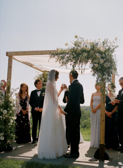 Bride and groom exchange vows at Kingdom of the Hawk wedding ceremony in Connecticut vineyard.